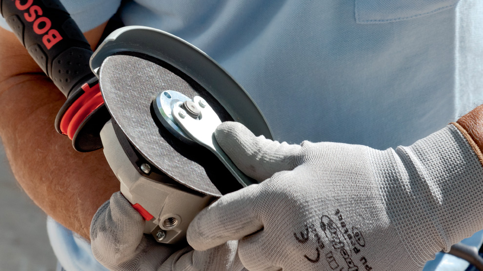 Một người đang cầm máy chà nhám Bosch Professional.