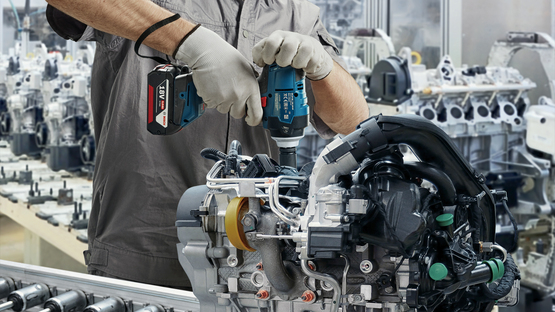 Công nghiệp Một công nhân đội mũ bảo hiểm và đeo mặt nạ đang sử dụng công cụ chuyên nghiệp của Bosch.