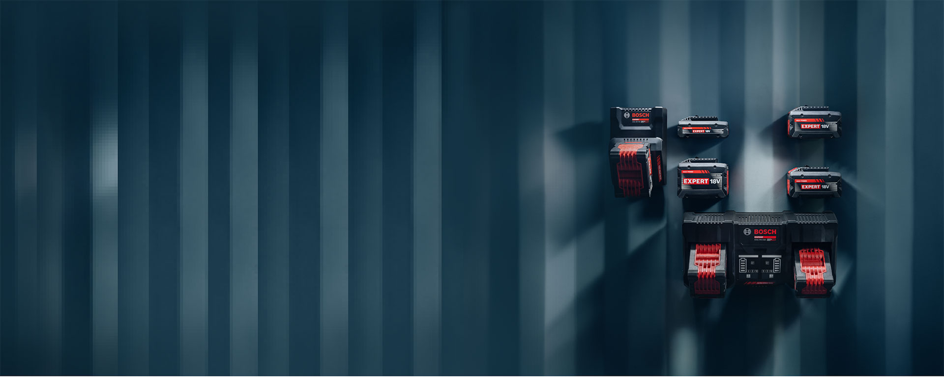 Nhiều loại pin Bosch Professional được gắn trên tường màu xanh.