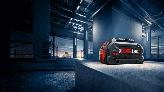 Lợi ích của Hệ thống 18V Một viên pin Bosch Professional màu đen trên một khối bê tông màu xám tại một công trường xây dựng.