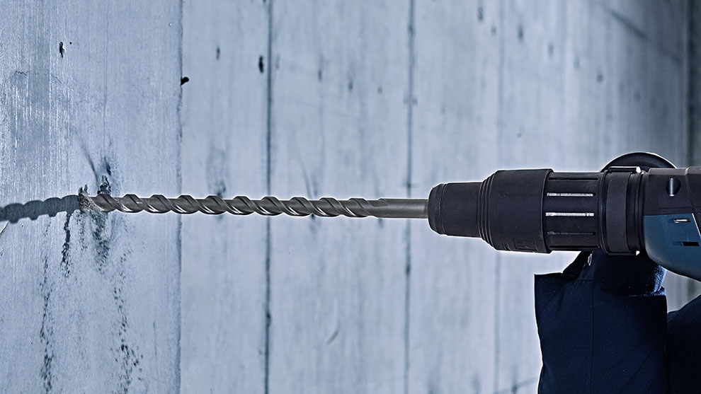 Một chiếc khoan Bosch Professional đang được đưa vào tường bê tông.