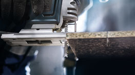 Một chiếc cưa lọng Bosch Professional đang cắt qua một tấm gỗ.