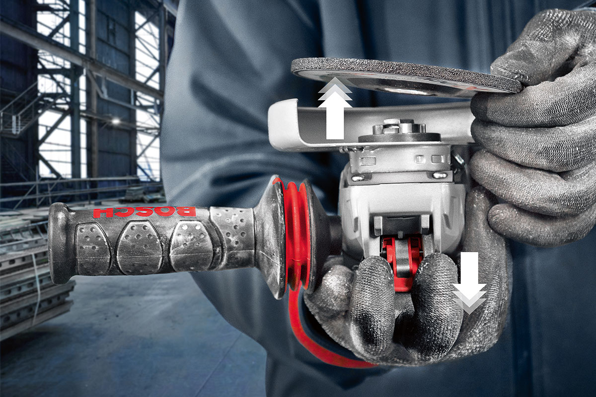 Hai bàn tay giữ một máy chà nhám Bosch Professional trong một xưởng.